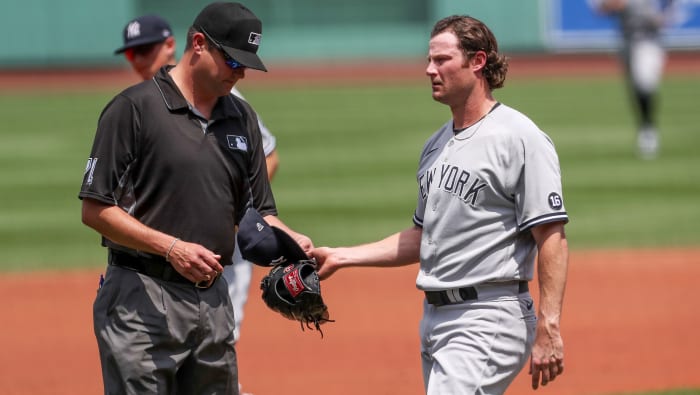Jun 27, 2021; Boston, Massachusetts, USA; Umpires check the hat and glove of New York Yankees starting pitcher Gerrit Cole (45) during the first inning against the Boston Red Sox at Fenway Park.